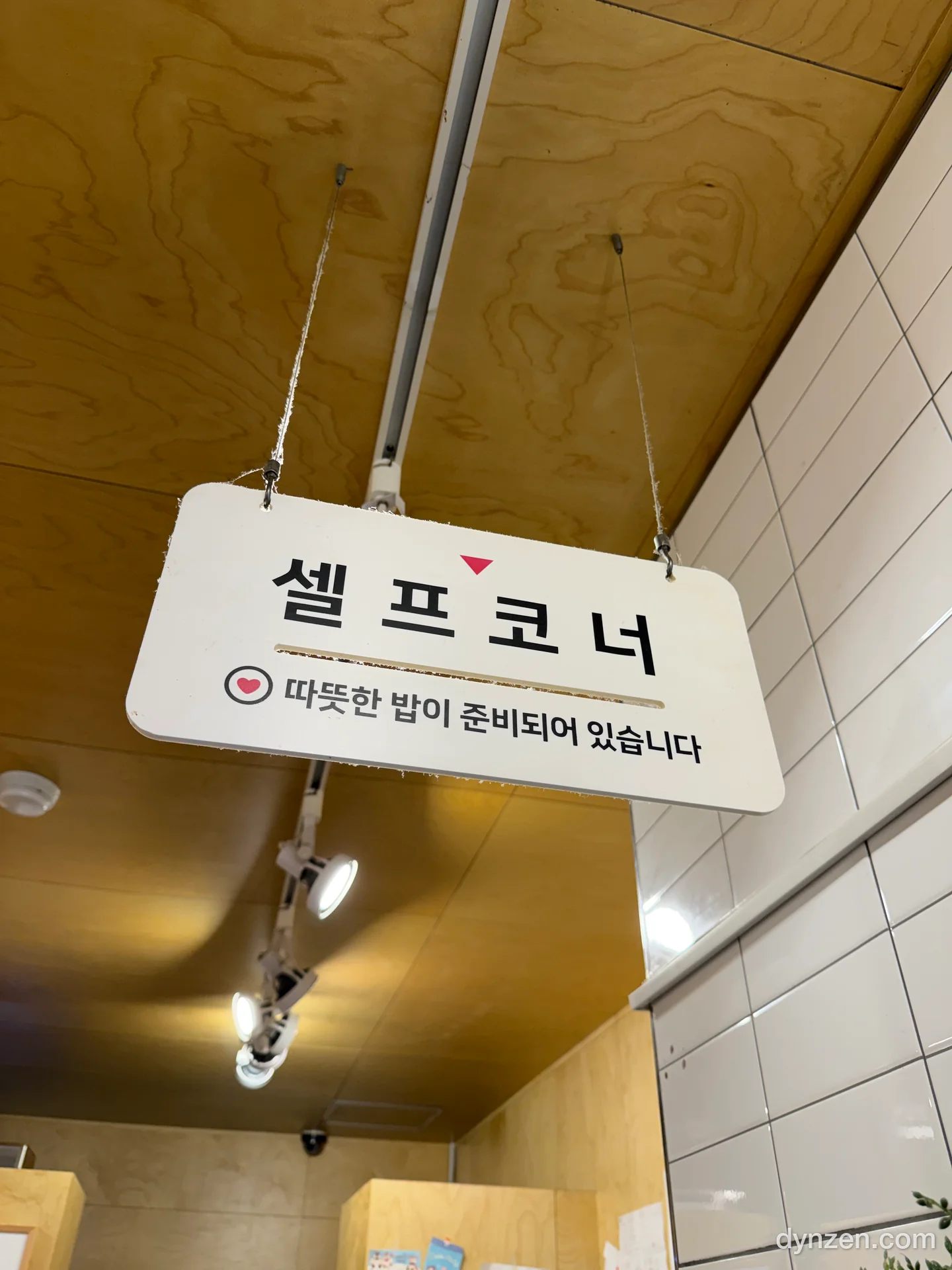 나무 천장에 매달린 ‘셀프코너’ 표지판, 따뜻한 밥이 준비되어 있다는 안내